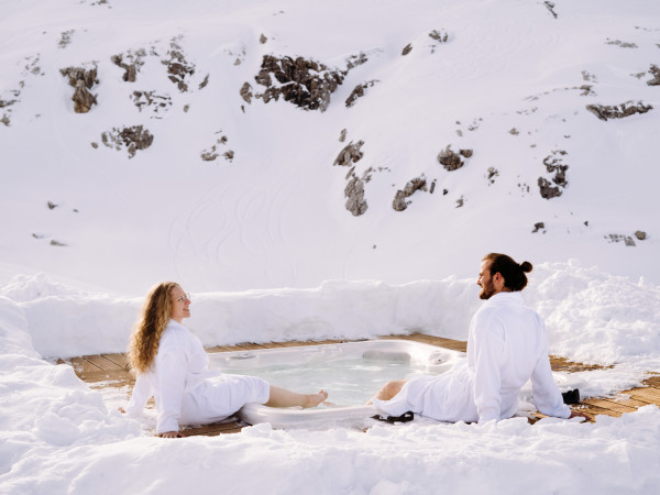Paar geniesst den Aussenwhirlpool beim Iglu-Dorf Davos Klosters